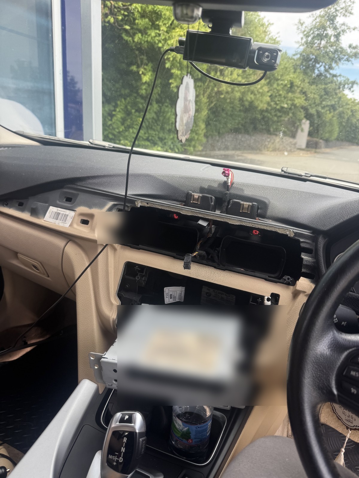 BMW 320d F30 dashboard during screen retrofit with private labels blurred